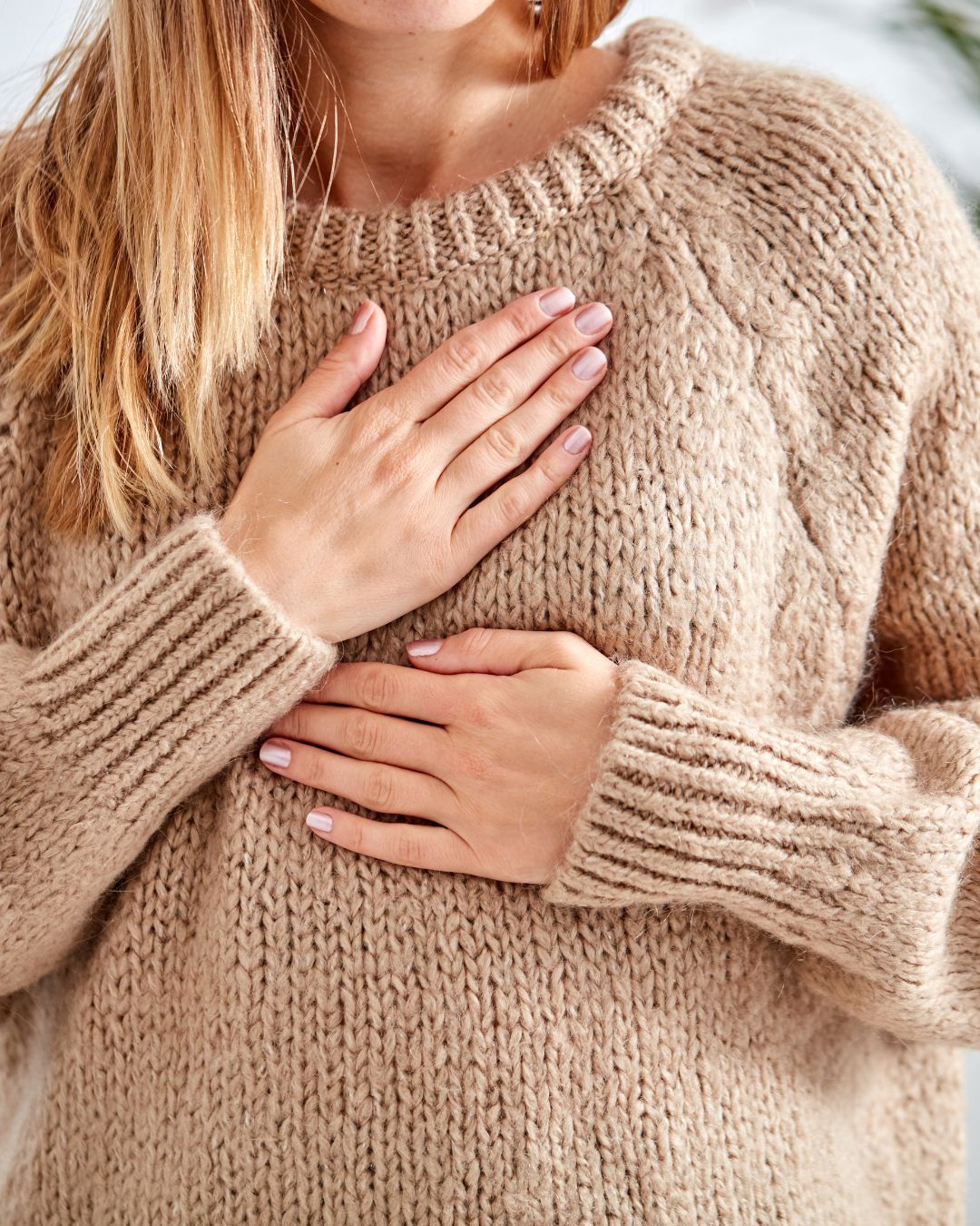 women taking conscious breath with hand on heart and belly