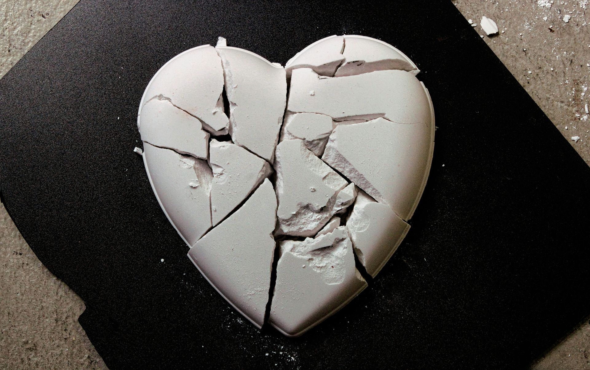 Cracked white heart-shaped object on a dark background