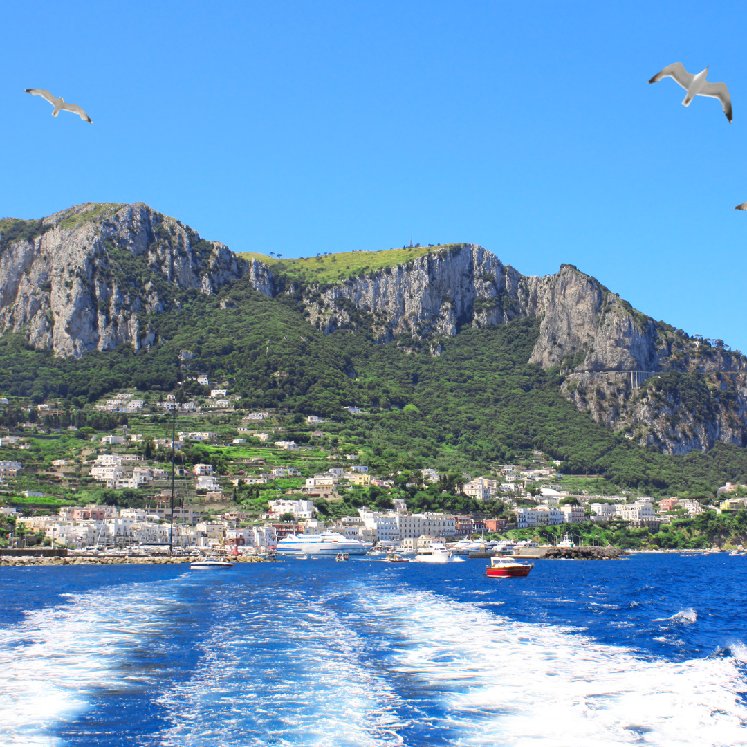 Private boat cruising along the Sorrento coastline with cliffs and blue sea