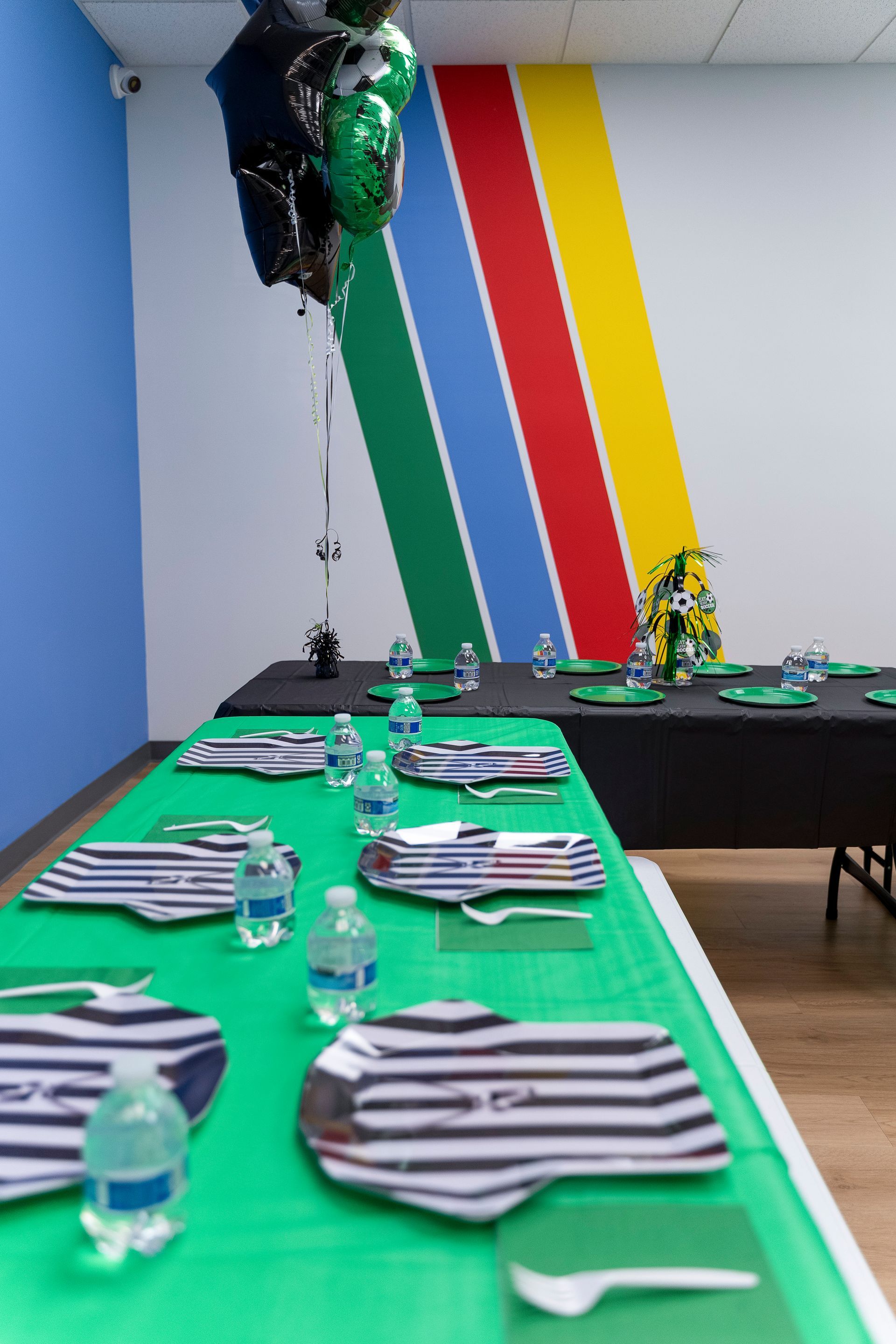 Decorated banquet table with striped napkins and balloons in a colorful party room