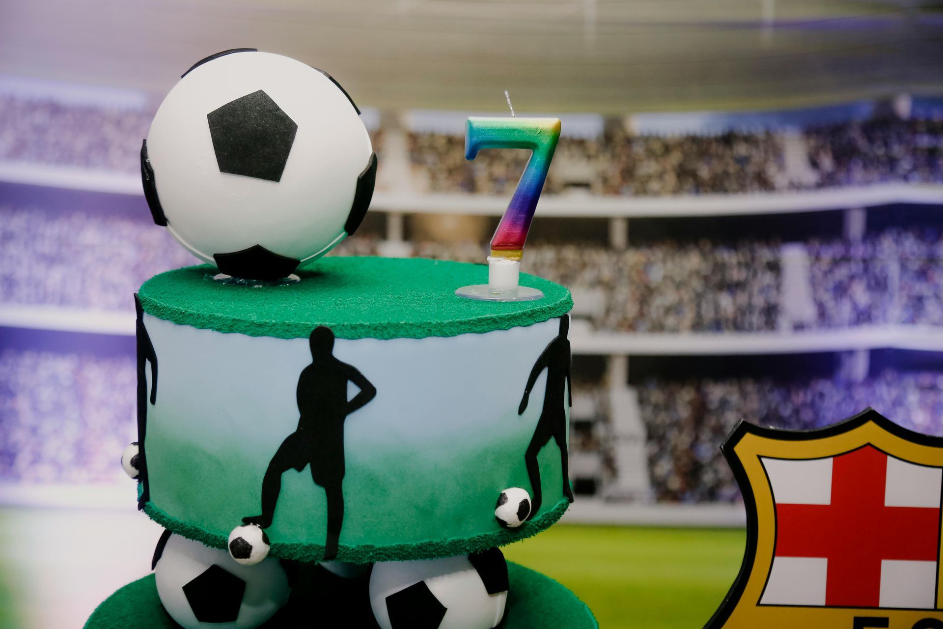 Soccer-themed number 7 cake with a ball topper and FC Barcelona crest