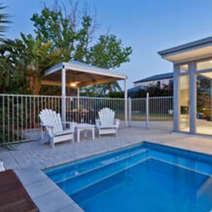 White aluminum pool fence around in-ground pool.