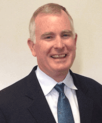 A man in a suit and tie is smiling for the camera.