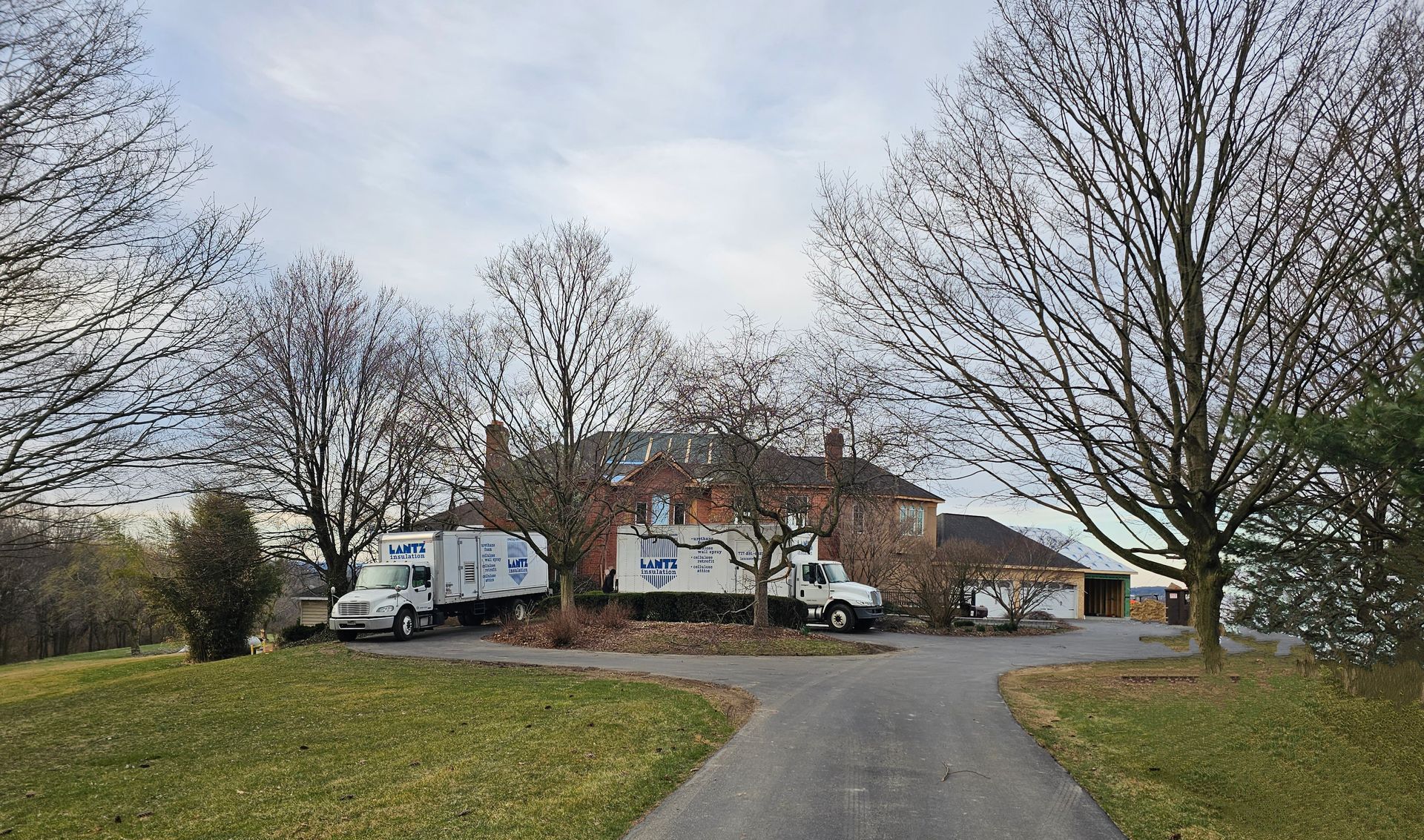 House with Lantz trucks in front a couple of trucks are parked in front of a house .