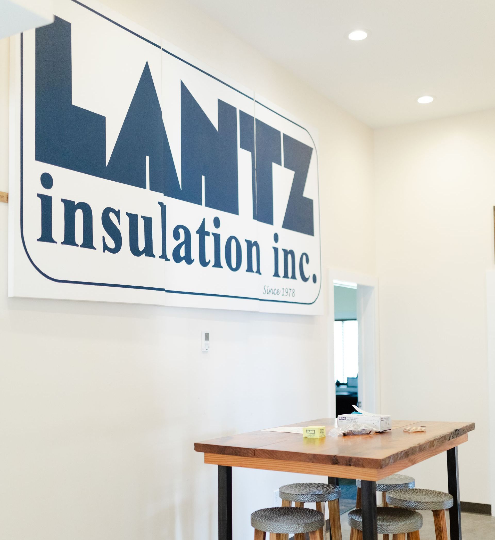 Lantz insulation sign a sign for lantz insulation inc. hangs above a wooden table