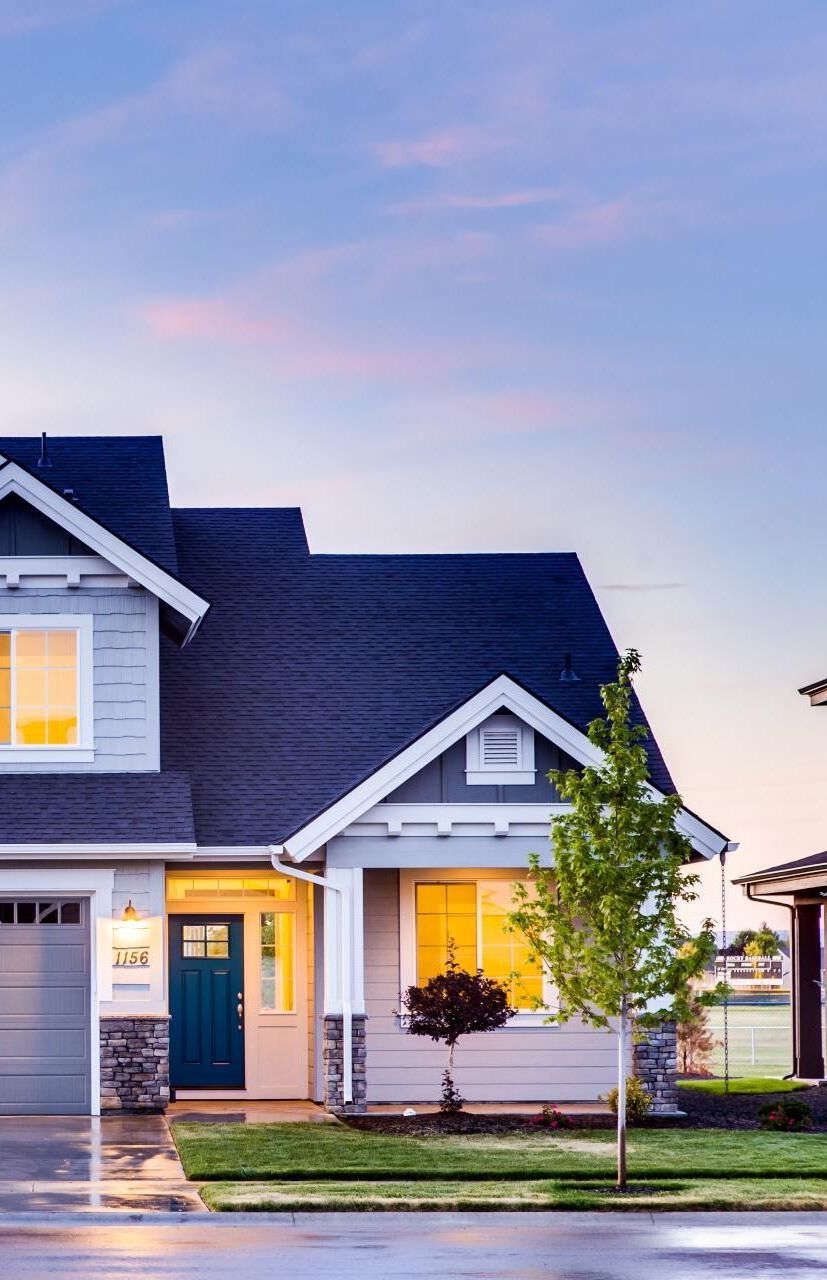 A large house with a blue roof is sitting on a lush green lawn. A large house with a blue roof is sitting on a lush green lawn.