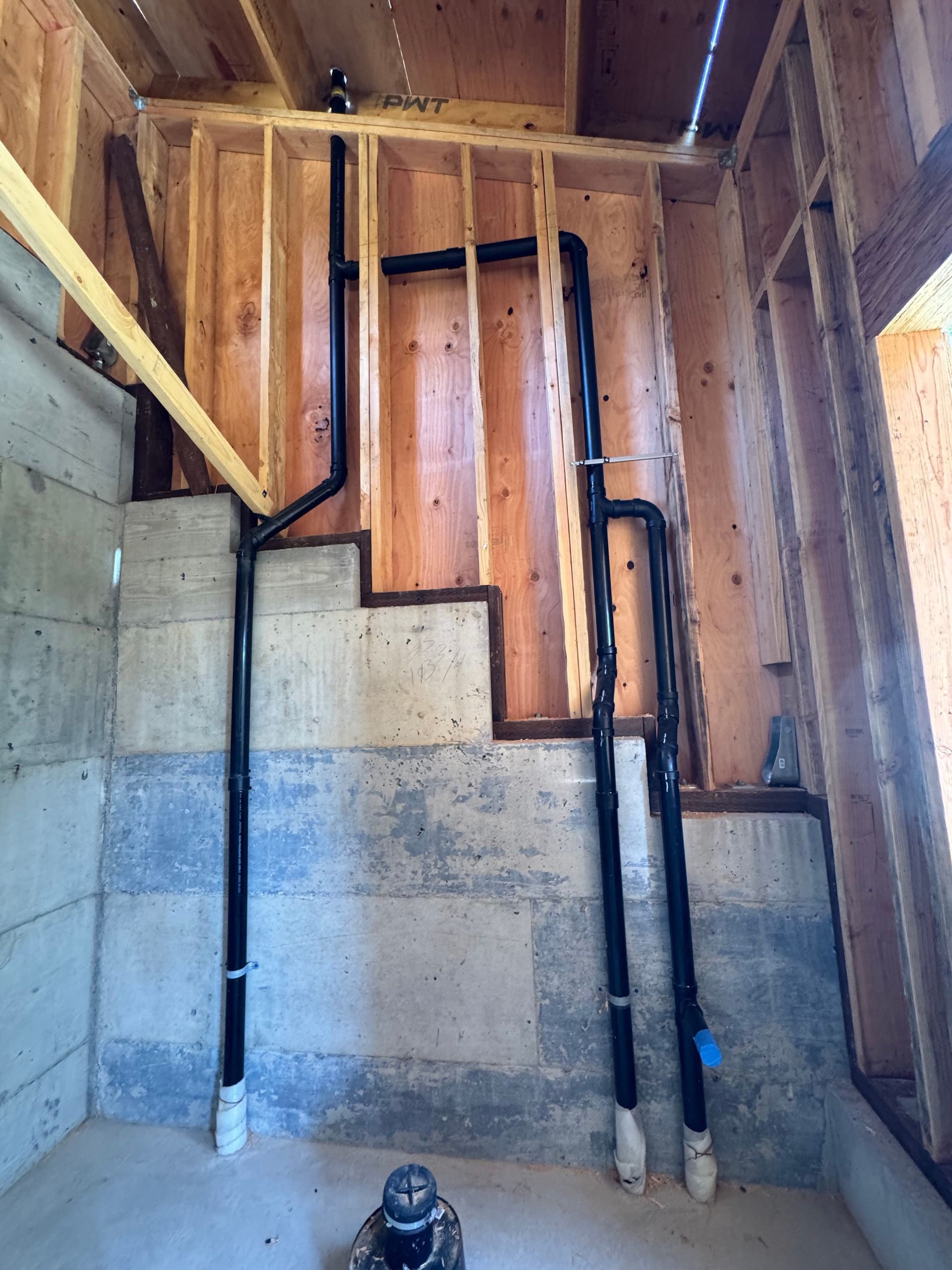 A room with a staircase and pipes in it