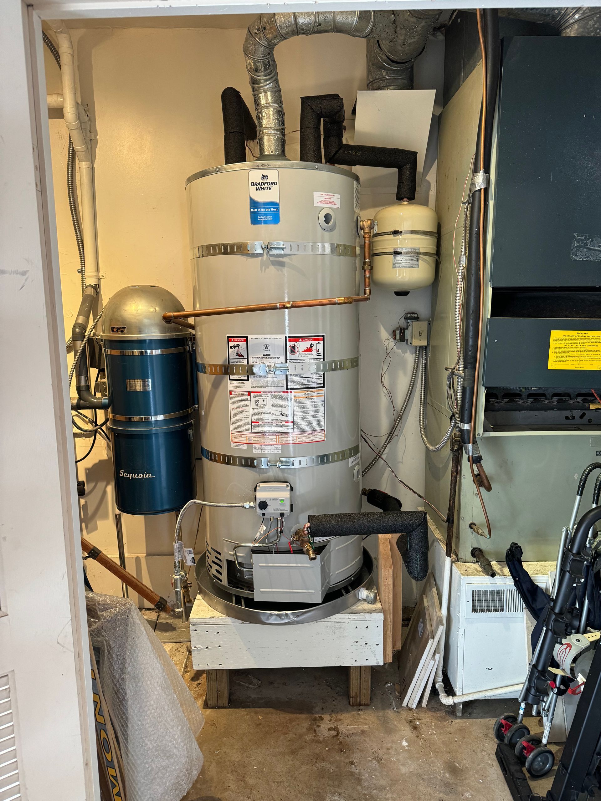 A water heater is sitting in a room next to a wall.