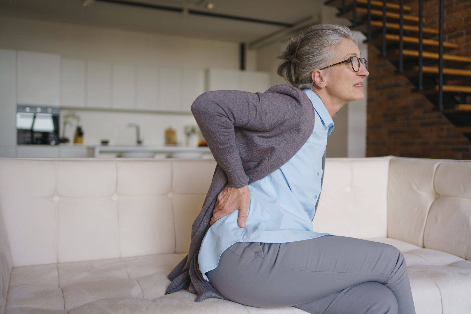 Senior woman suffering from back pain at home. Senior woman suffering from back pain at home.