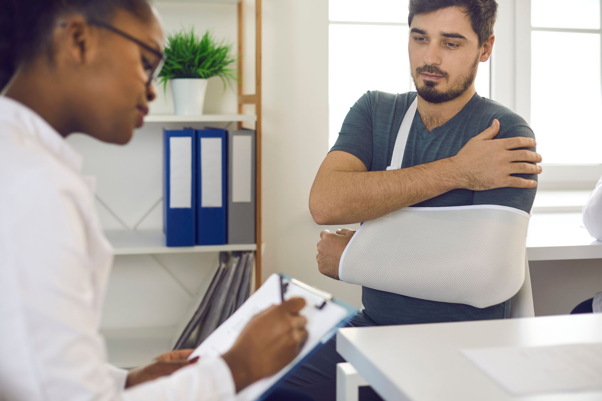 Doctor at hospital prescribing treatment and talking to young patient. Doctor at hospital prescribing treatment and talking to young patient.