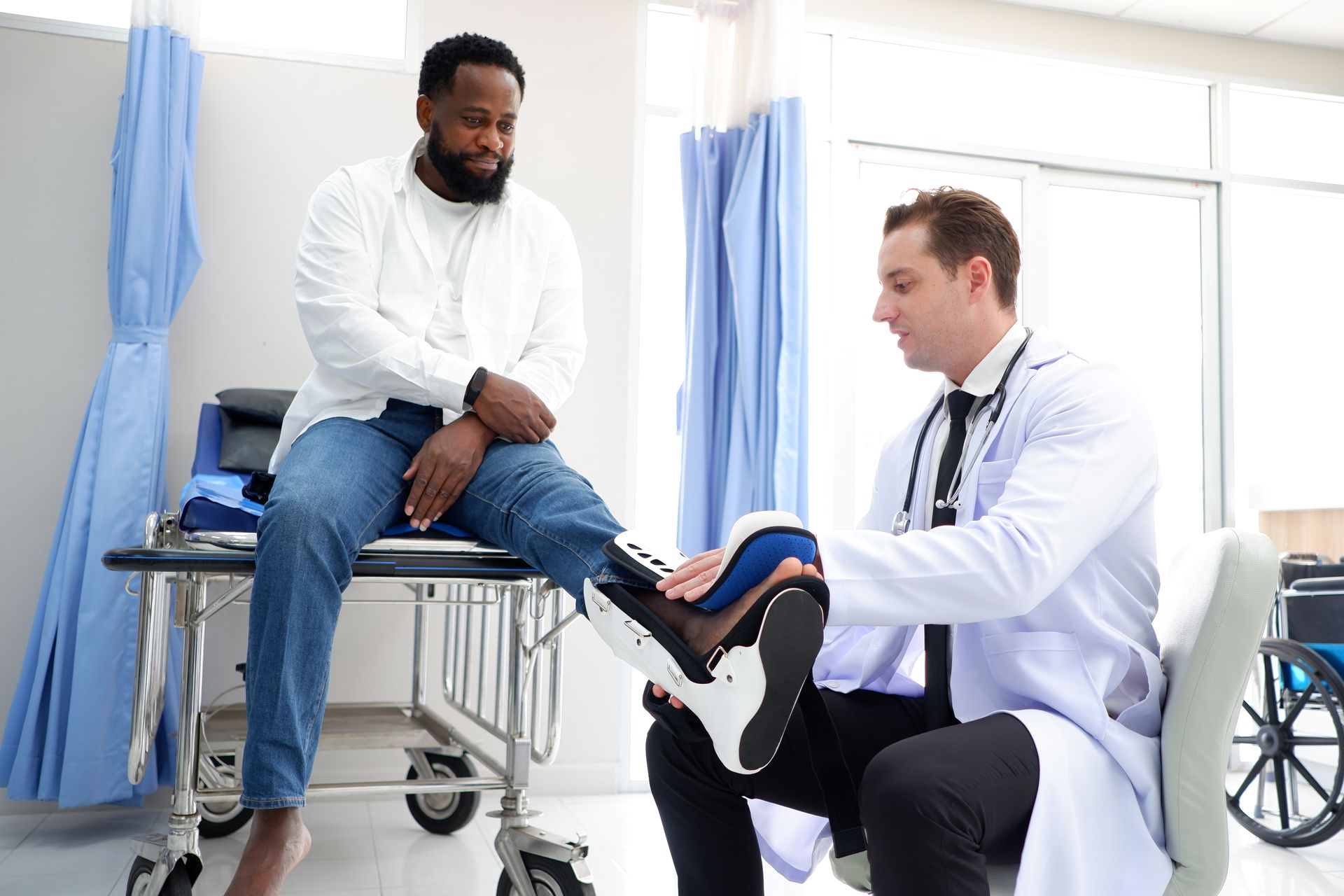 Doctor evaluating a patient's knee brace during a musculoskeletal injury examination.