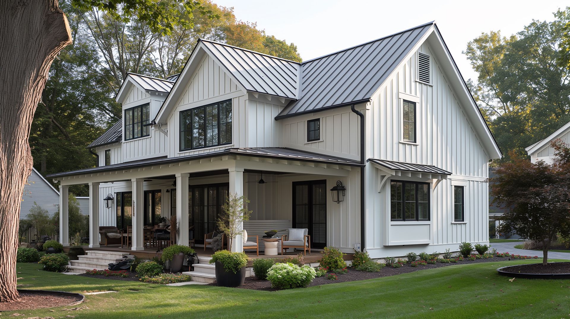 White farmhouse with black trim, a porch, and a metal roof in a grassy yard.