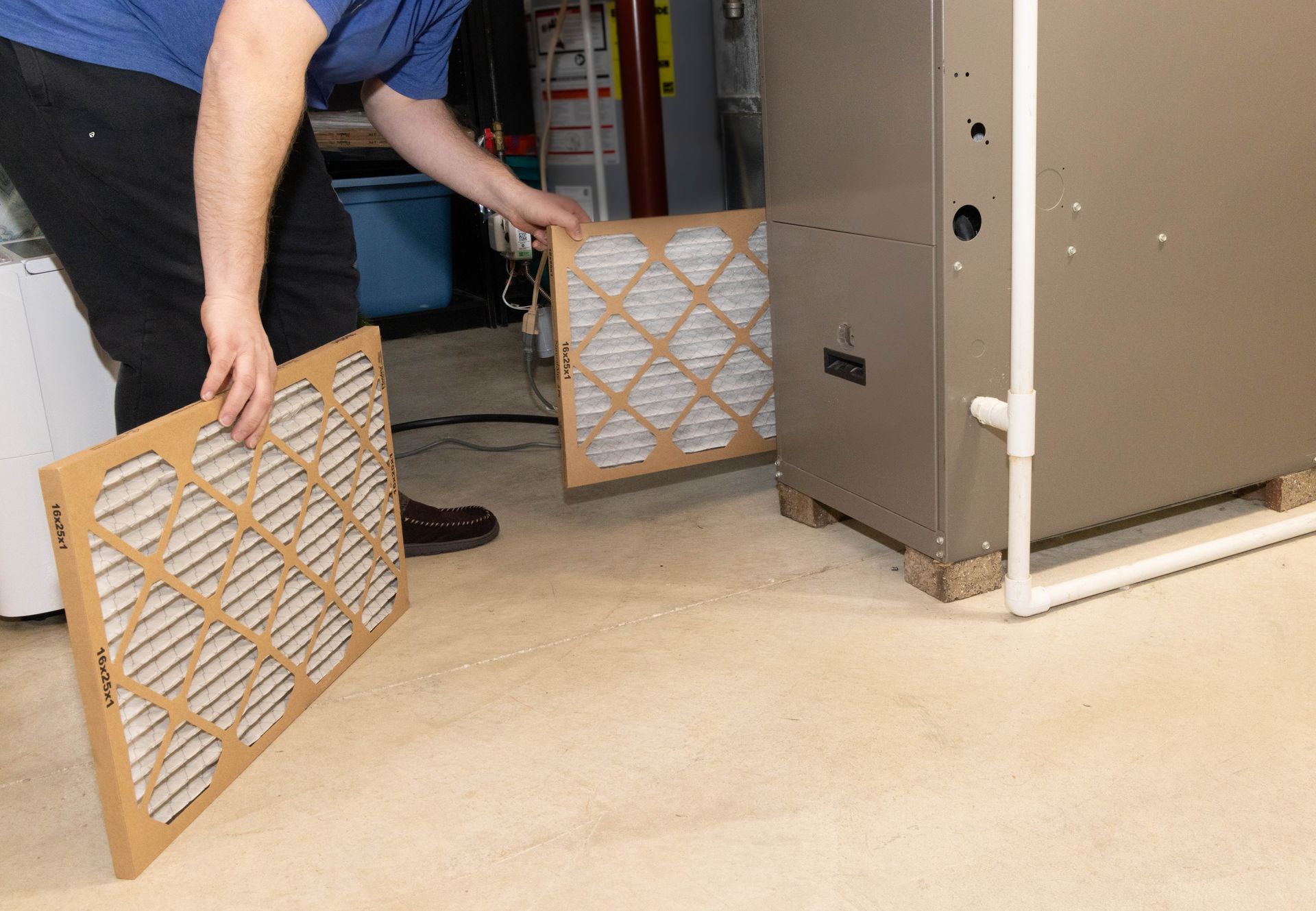 Person replacing a furnace air filter.