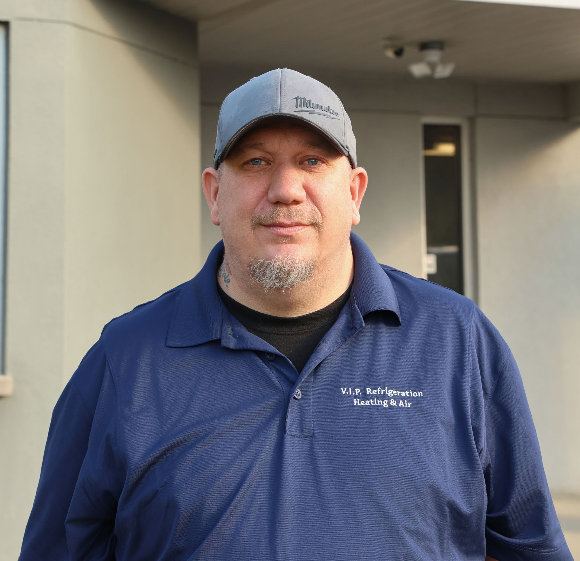 HVAC technician using gauges on an outdoor air conditioning unit.