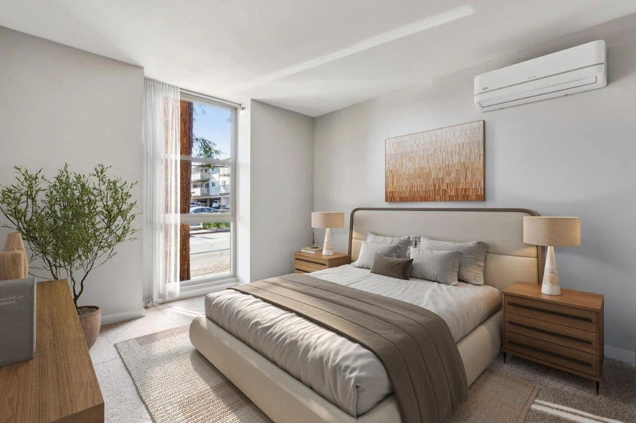Bedroom with bed, nightstands, and art. Large window and air conditioning unit visible.