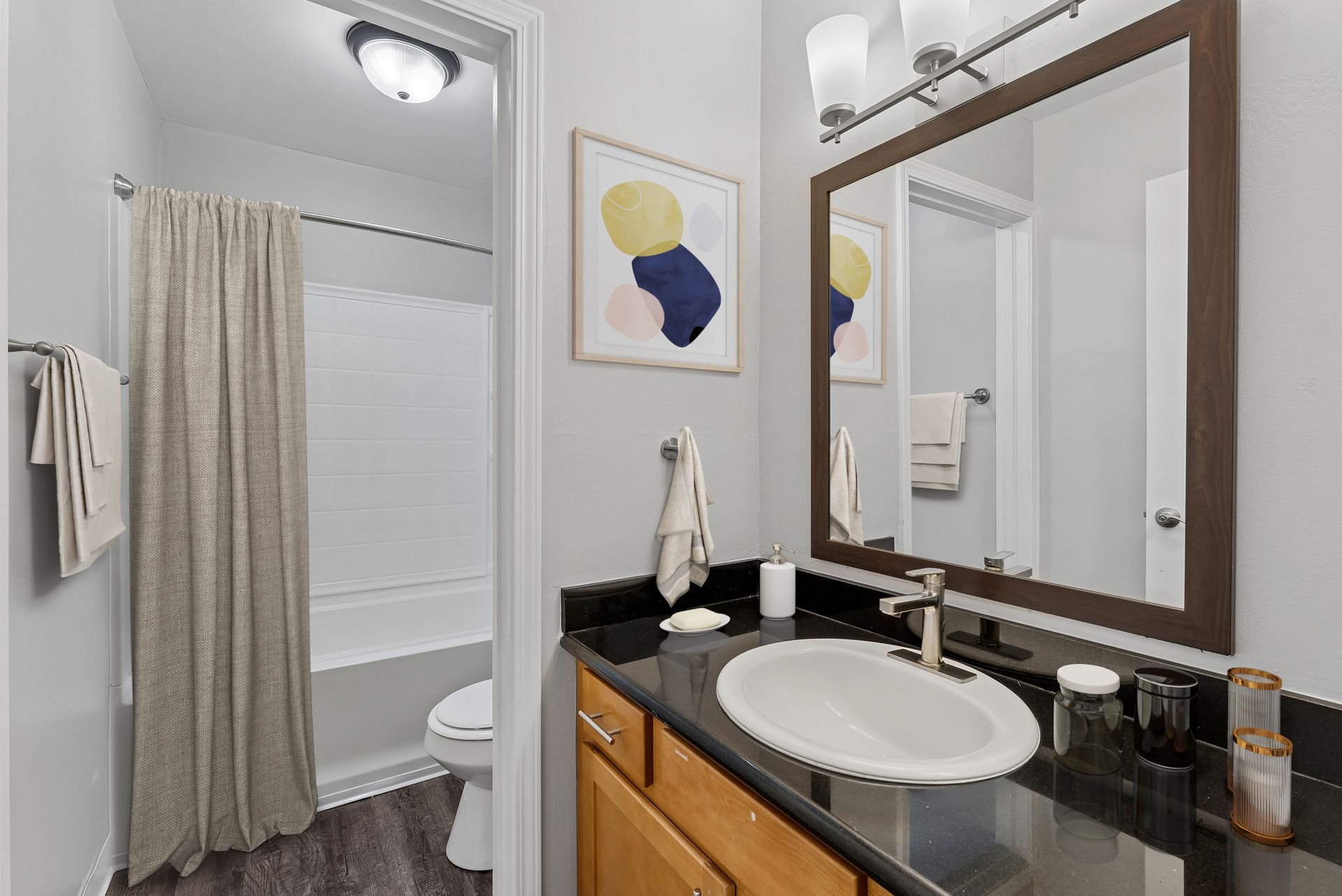 Modern bathroom with vanity, sink, mirror, and shower curtain in a small, bright space