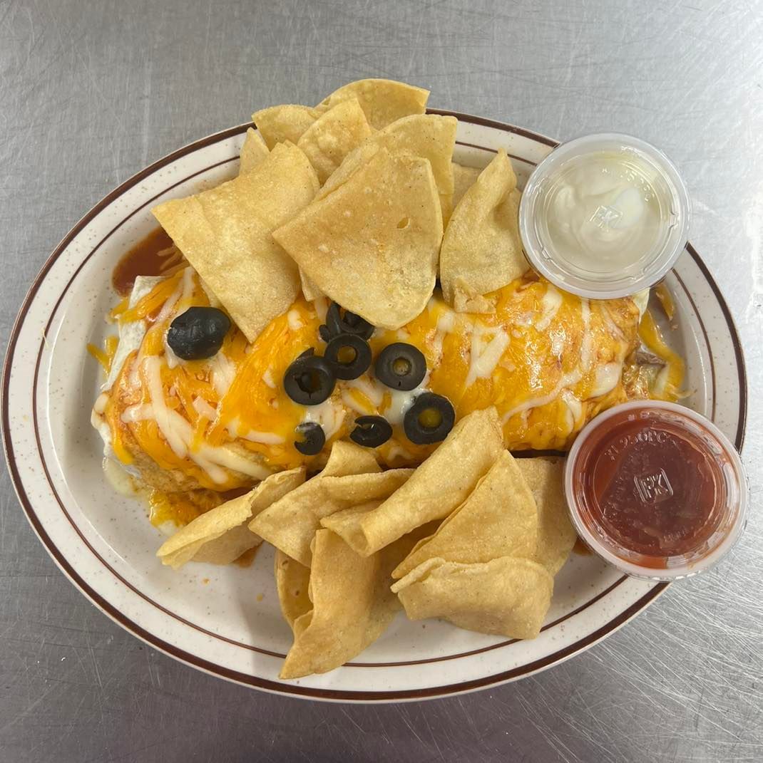 A plate of food with tortilla chips and sauce on a table.