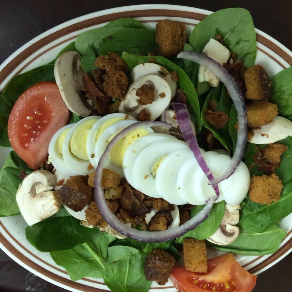 A salad with eggs tomatoes and onions on a plate