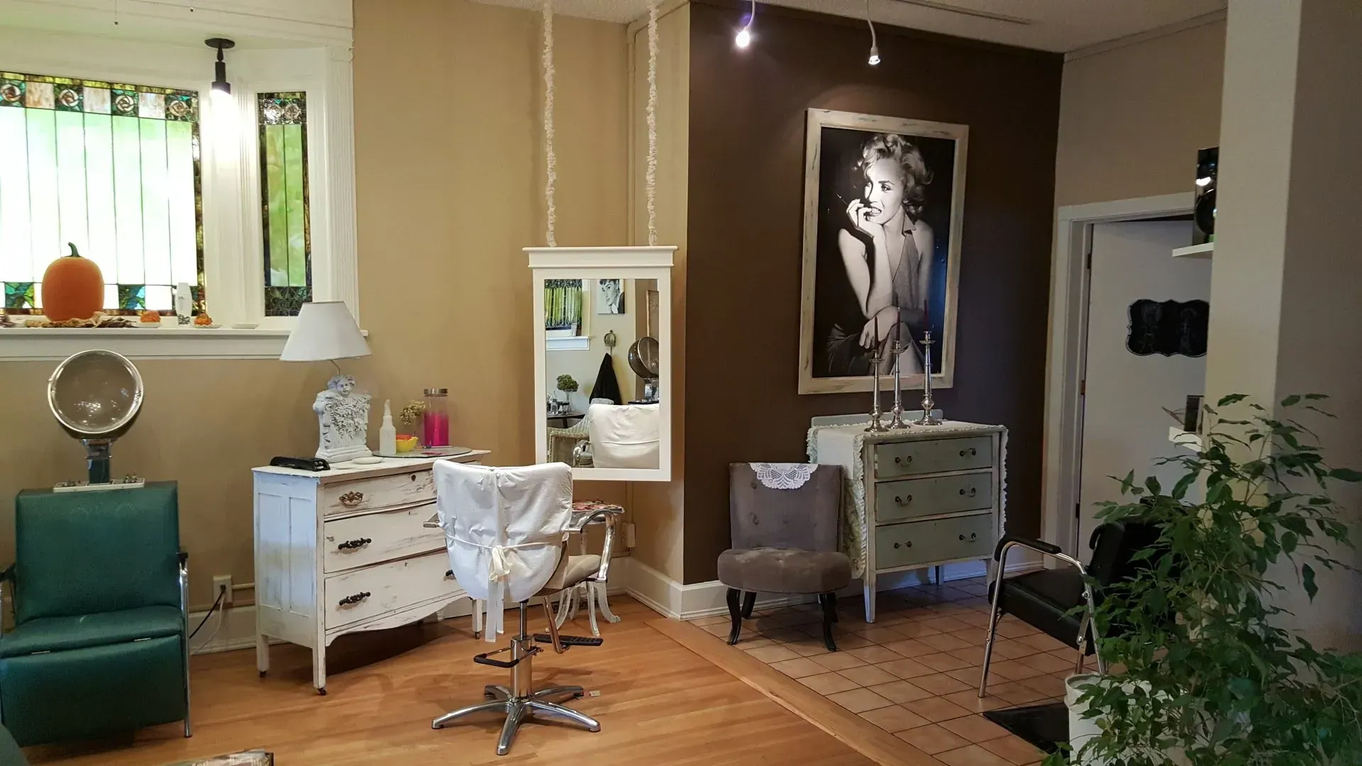 A salon with chairs a dresser and a mirror