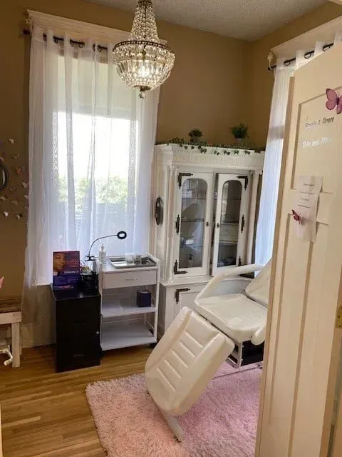 A room with a white chair and a chandelier hanging from the ceiling