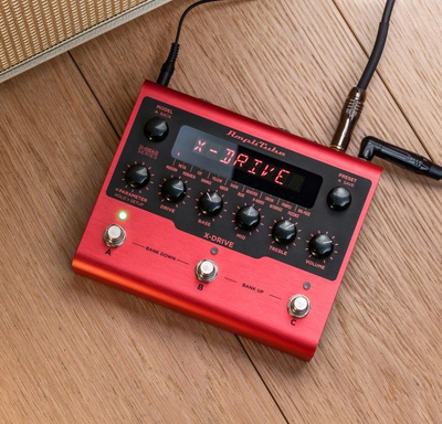 Red guitar effects pedal on wood, labeled