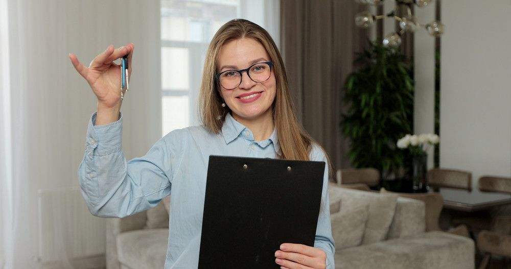 Woman with clipboard holding keys — Wollongong Strata