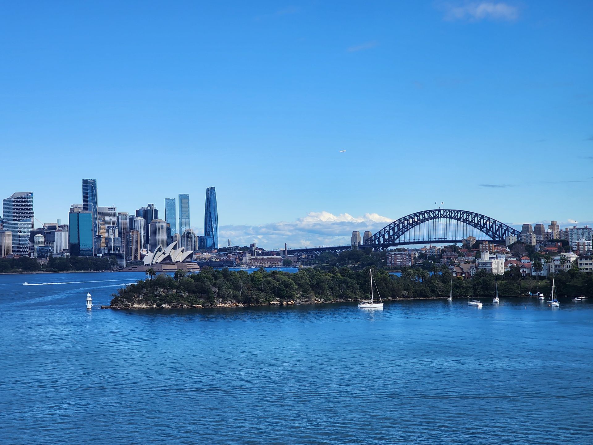 Sydney Harbour skyline with the Harbour Bridge over blue water on a clear day