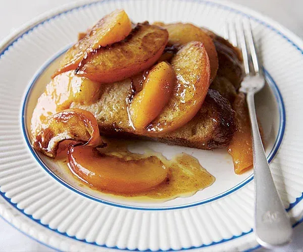 Caramelized apple dessert on a white plate with a fork