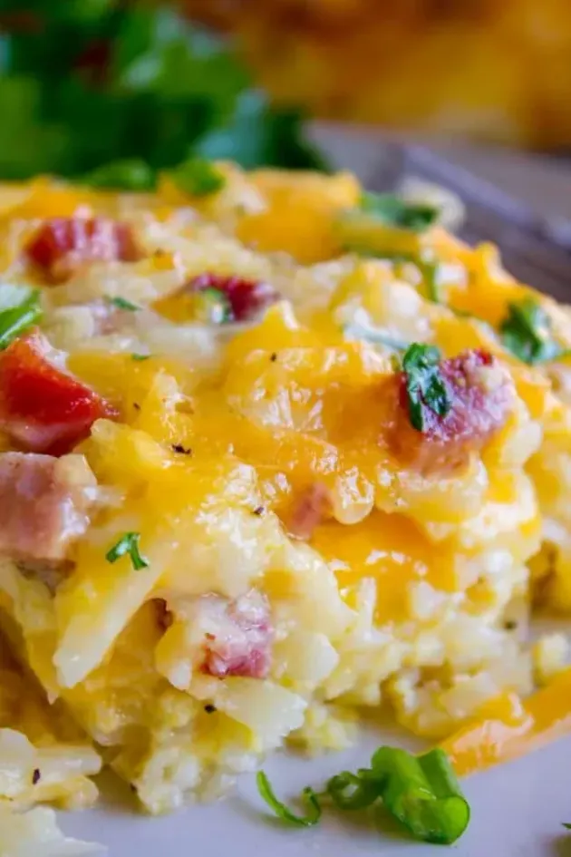 Cheesy bacon potato casserole topped with parsley in a close-up serving dish