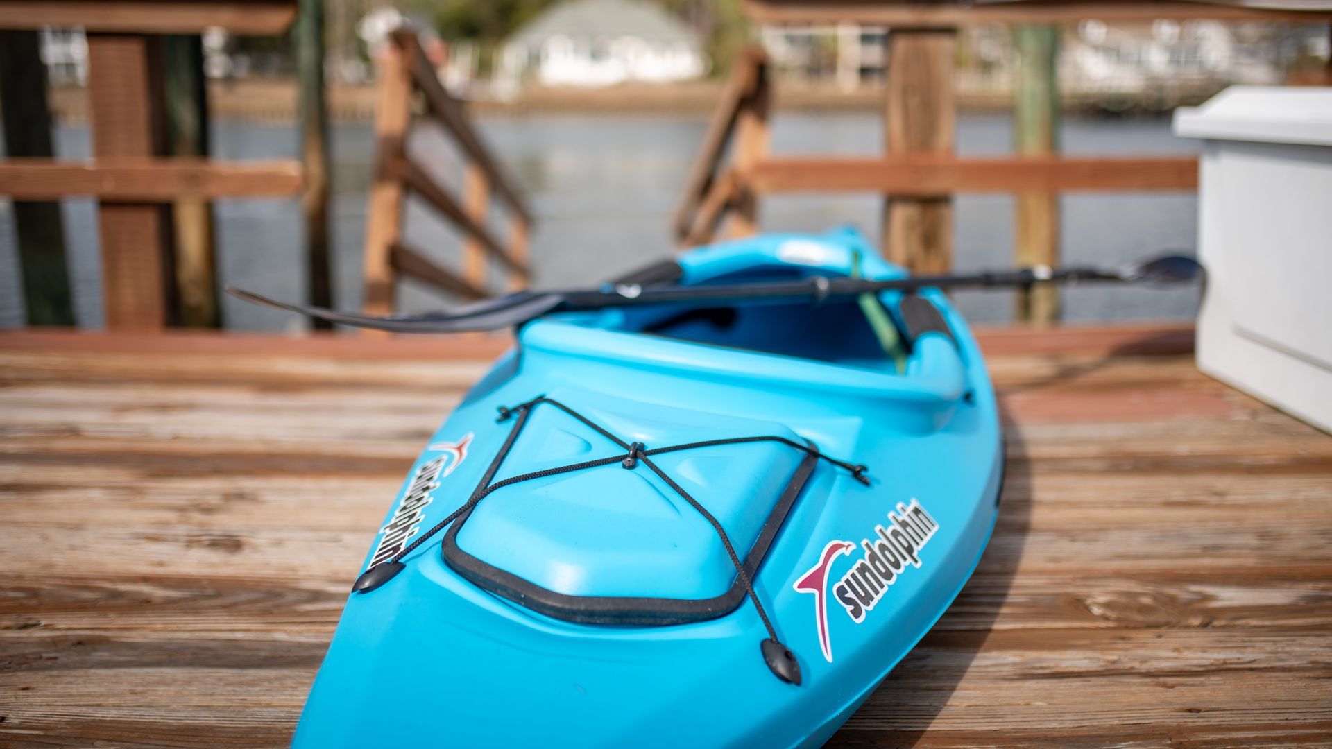 Blue kayak resting on a wooden dock near the water