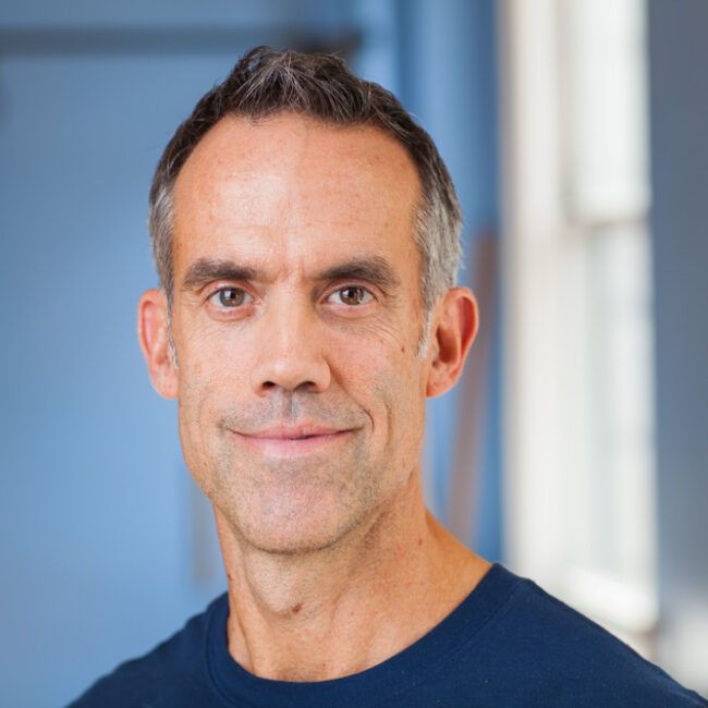 Portrait of a man in a blue shirt against a blurred blue background