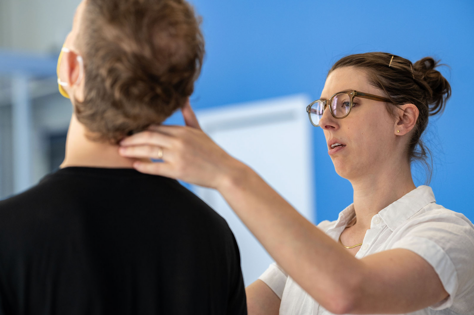 Hands performing a back massage on a person lying on a table.
