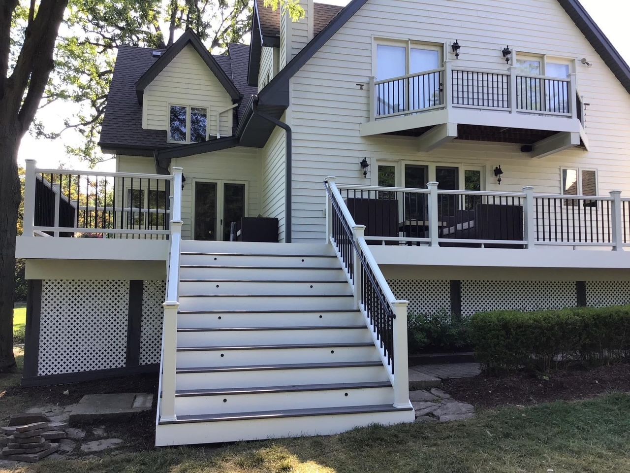 Front view of a white house with a central staircase and multiple balconies and decks
