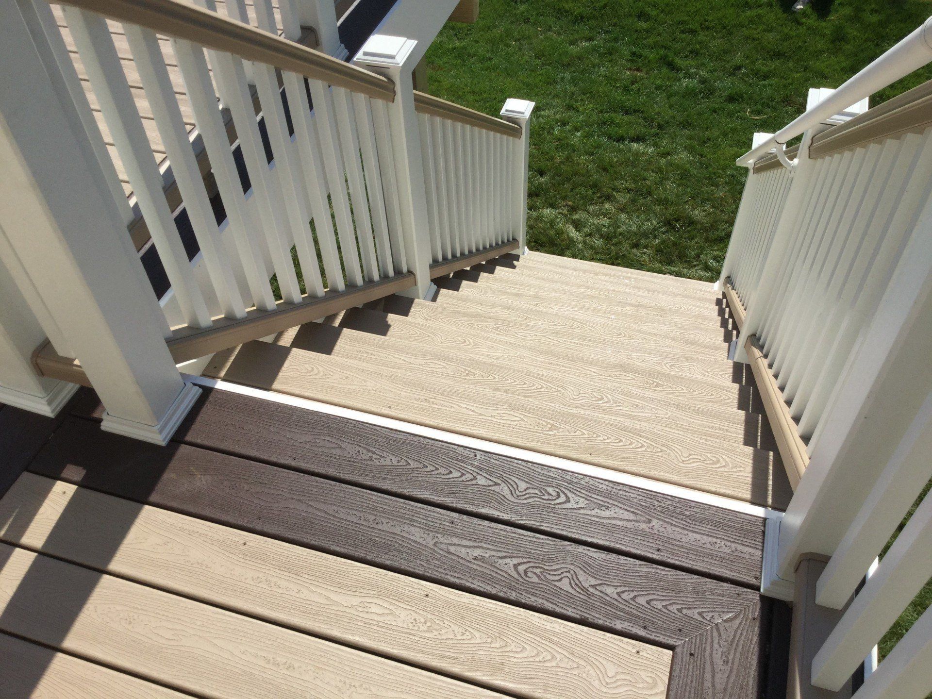 Stairway down to a backyard, with white railings and a short landing.