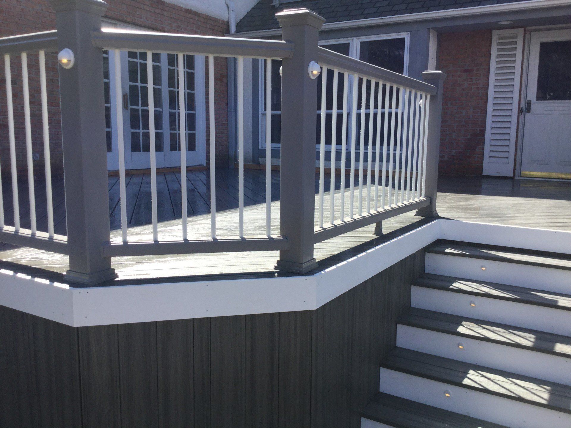 House porch with gray railing and stairs leading to a front door