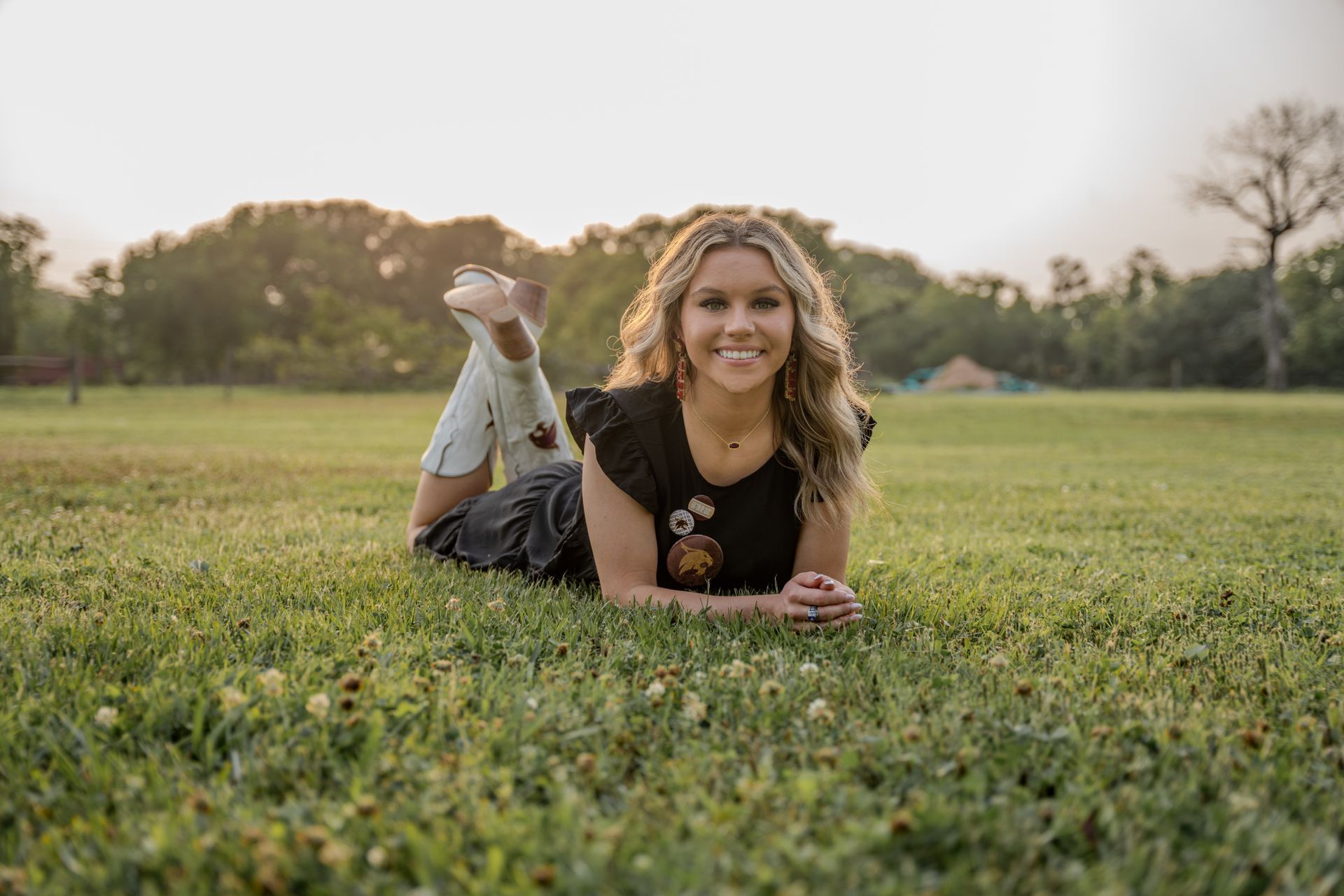 A woman is laying on her stomach in the grass.