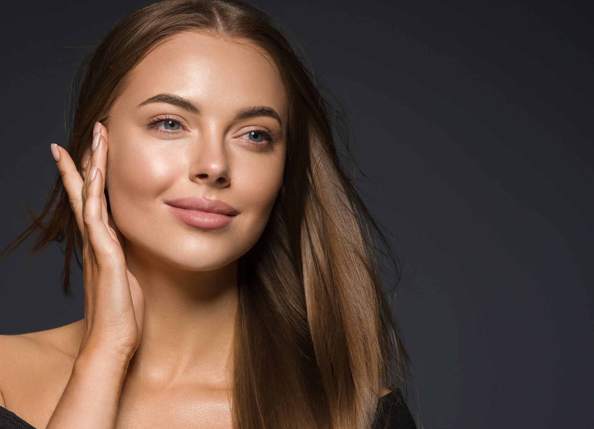 Photo of a beautiful, confident woman , showcasing her naturally enhanced cheeks and lips after hyaluronic acid filler injecions at Monaco Med Spa in Miami, FL