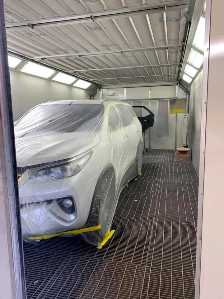 A Car is Being Painted in a Paint Booth — Arafura Crash Repairs in Darwin, NT