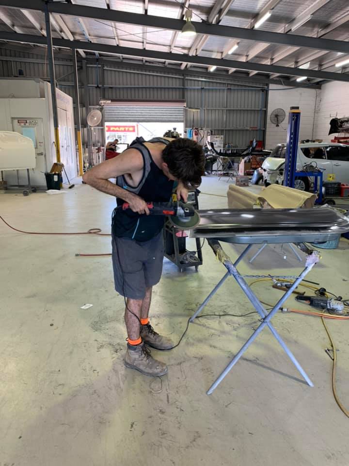 A Man is Working on a Piece of Metal in a Garage — Arafura Crash Repairs in Darwin, NT