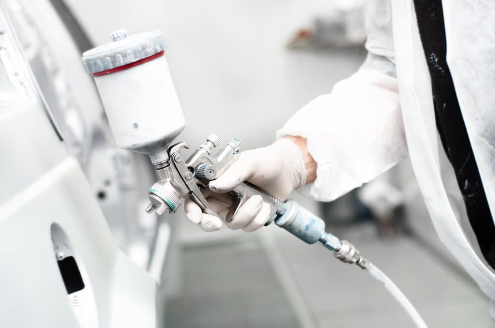 Close-up of Spray Gun Painting a Car