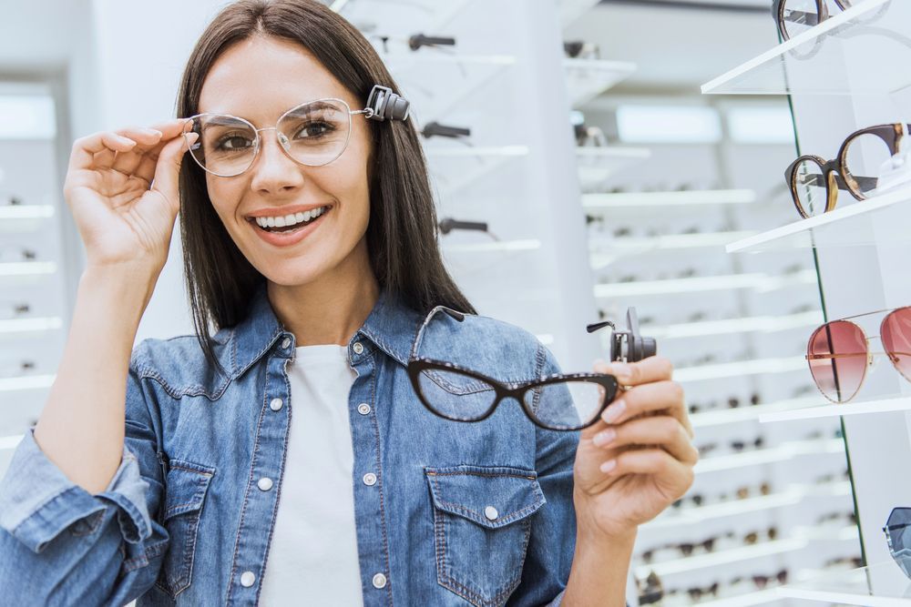 Una mujer sostiene un par de gafas en una óptica.