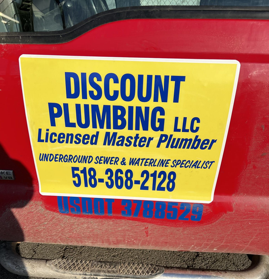 Man lying under a kitchen sink, fixing plumbing.