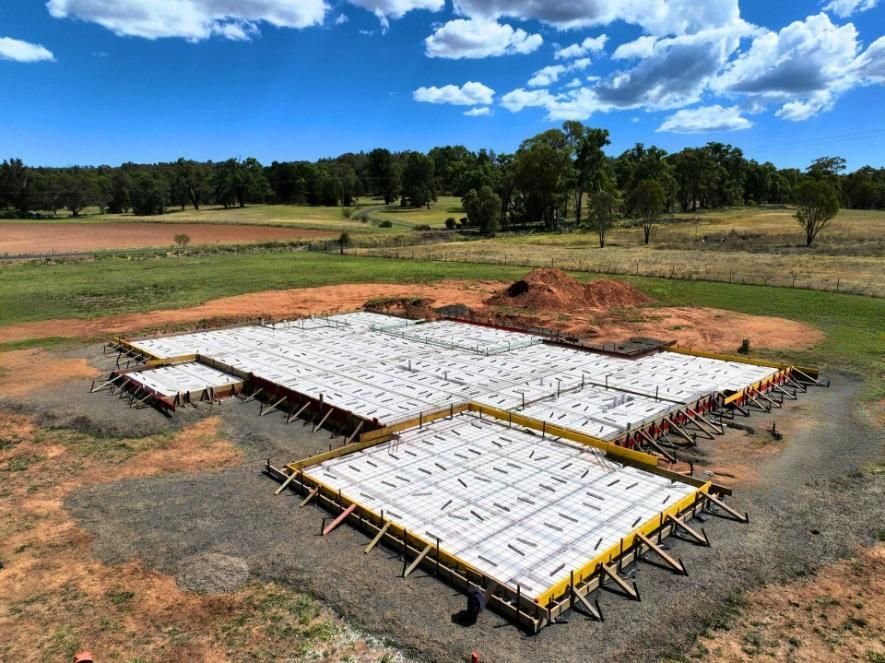 A Concrete Slab Is Sitting in The Middle of A Field — Spencer's Landscape Construction & Concreting Pty Ltd in Dubbo, NSW