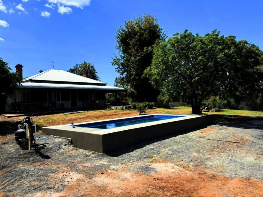 A House with A Large Swimming Pool in Front of It — Spencer's Landscape Construction & Concreting Pty Ltd in Forbes, NSW