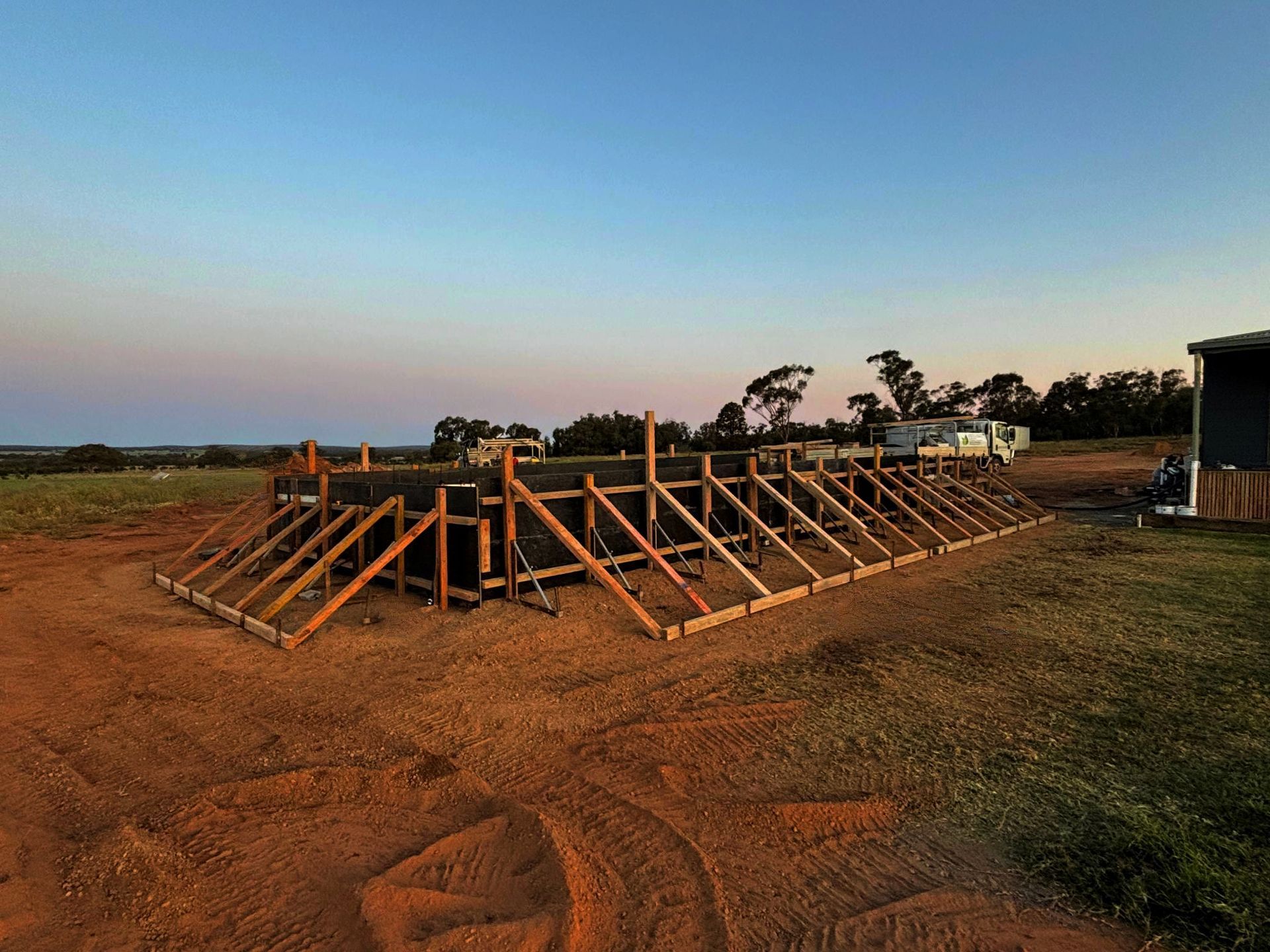 A Brick House with A Concrete Walkway in Front of It — Spencer's Landscape Construction & Concreting Pty Ltd in Dubbo, NSW