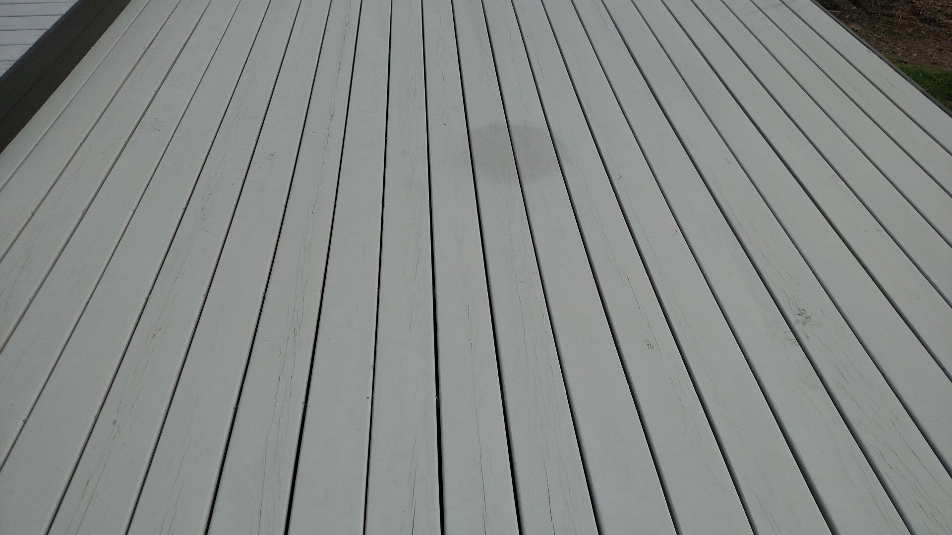Gray wooden deck boards stretching into the distance in a simple outdoor view