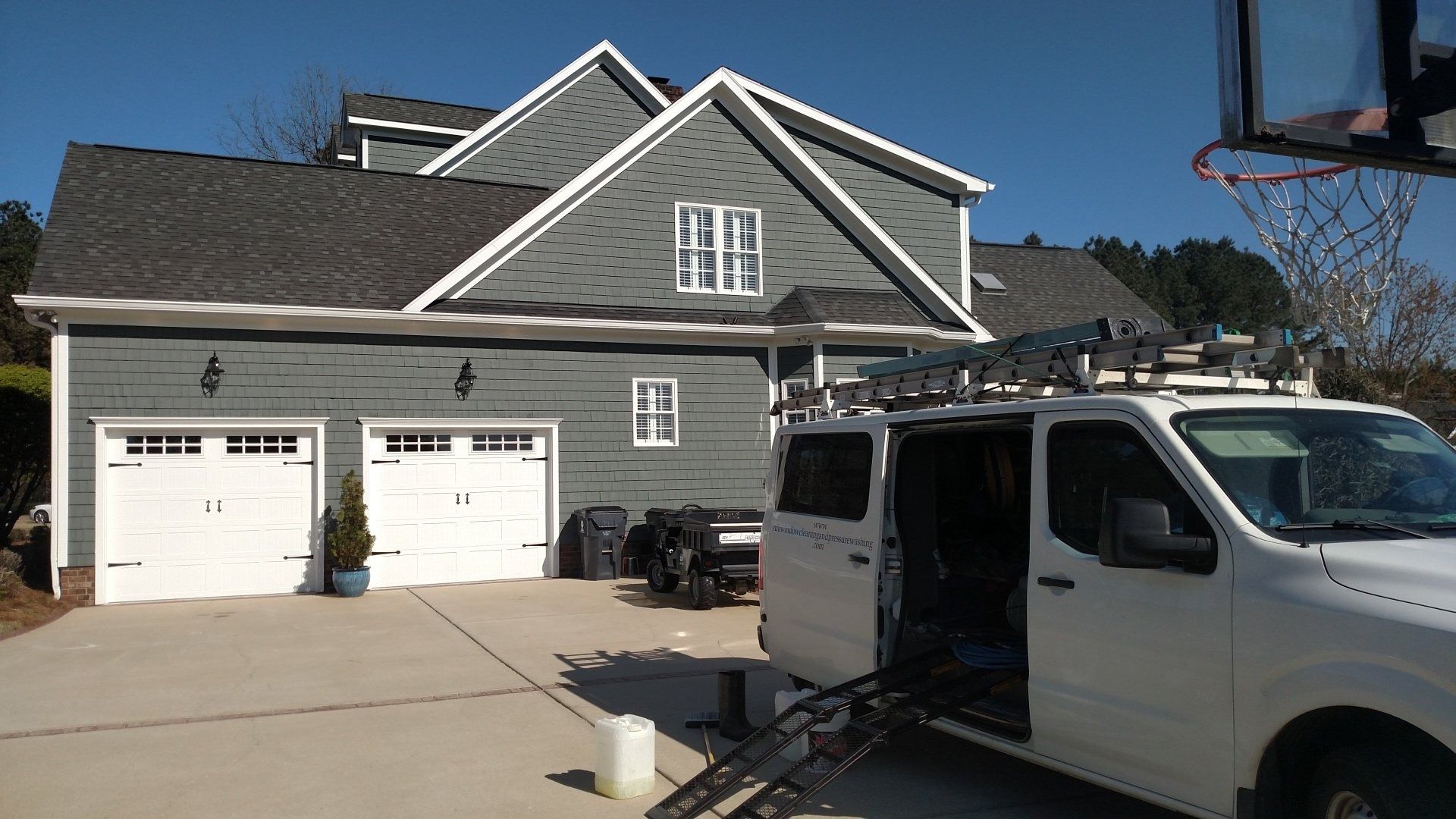 Suburban house with two garage doors and a white van parked in the driveway
