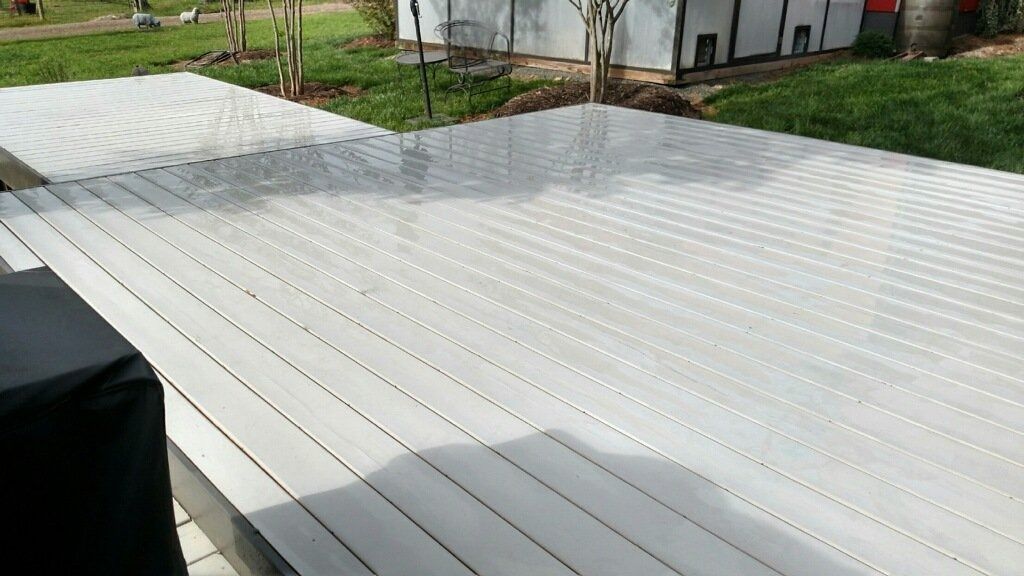 White corrugated metal roof beside a grassy yard and a small white building