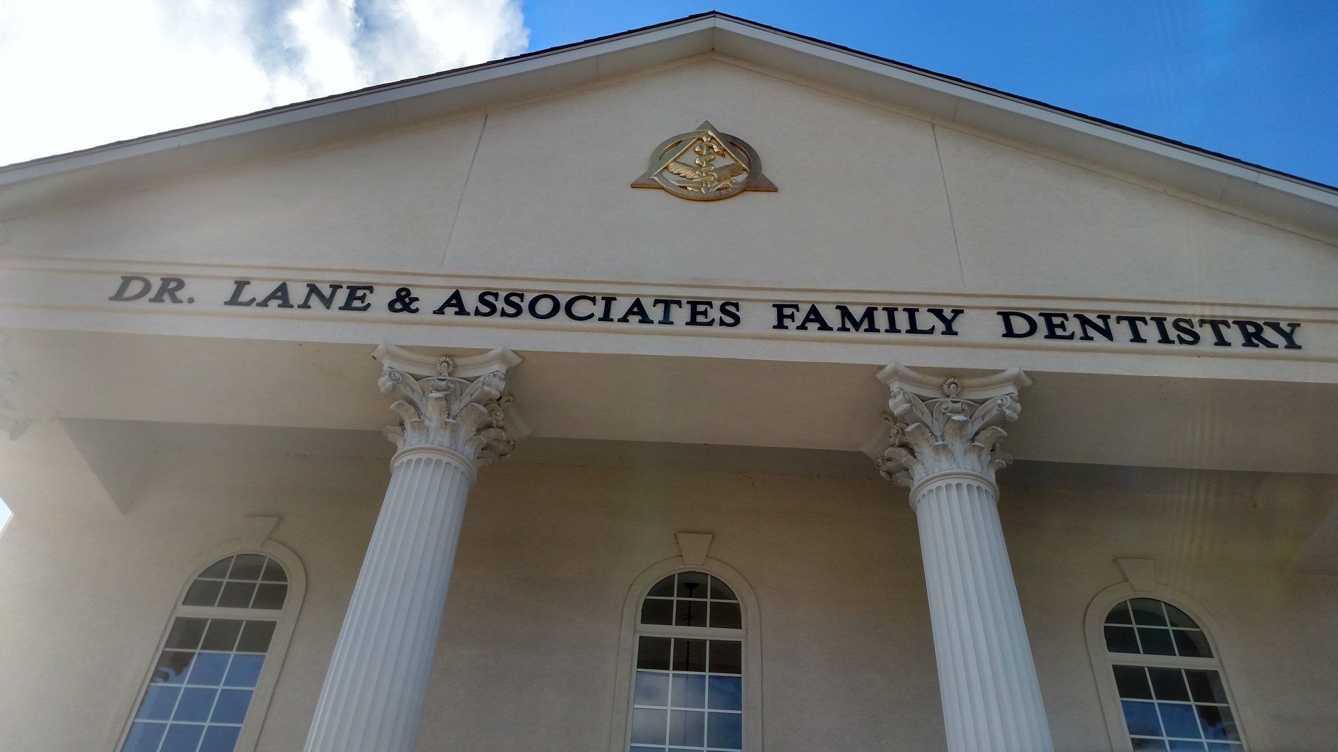 Exterior of Dr. Lane & Associates Family Dentistry with white columns and arched windows