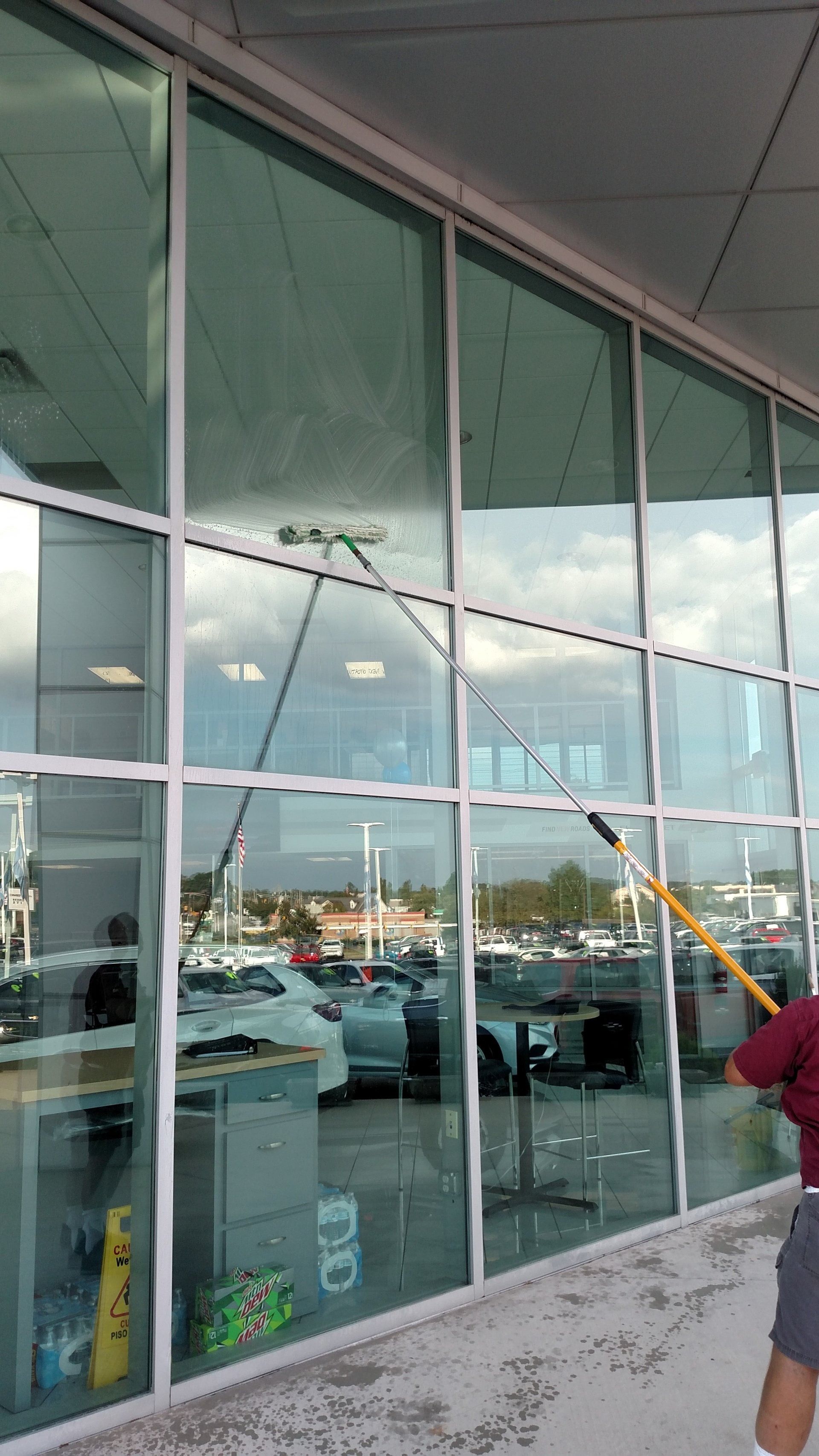 Cracked storefront glass with a large white diagonal fracture outside a parking lot